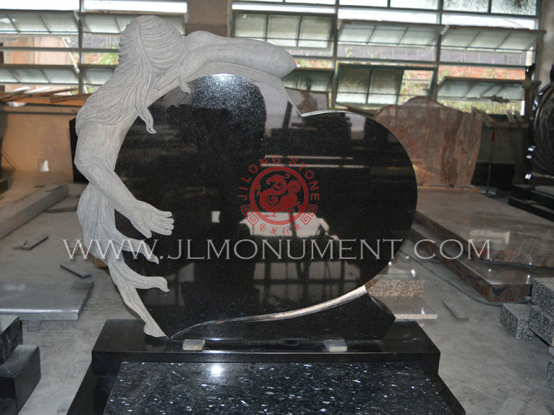 A single hand-carved angel sitting on a pedestal on the side of a flat top headstone.,and Absolute Black and Angel Headstone-034